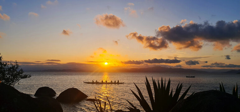 Por do Sol com canoagem na paisagem do mar calmo a c&eacute;u aberto