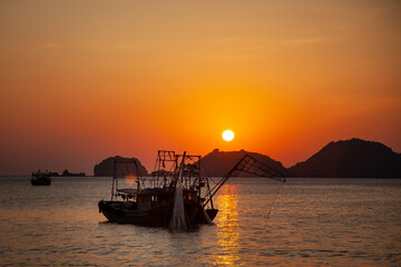 Bateau de pêche dans la mer au Vietnam au coucher du soleil