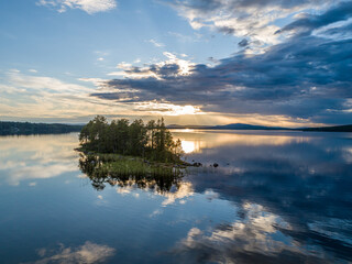 Aerial View Small Island in the Sandsjön Lake in Sandsjönäs, Swedish Lappland during Sunset with reflections in the water