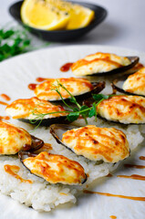 Baked mussels with cheese in shells on rice in a plate