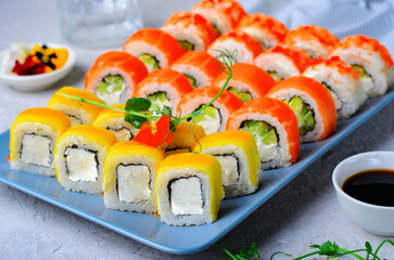 Sushi rolls set with salmon, shrimp and mango on light blue background, Japanese cuisine