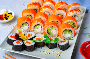 Sushi rolls set with salmon and shrimp on light blue background, Flower Shaped Sushi Rolls, Japanese cuisine