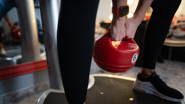 woman training on power plate machine with kettlebell