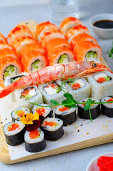 Sushi rolls set with salmon and shrimp on light blue background, Flower Shaped Sushi Rolls, Japanese cuisine