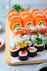 Sushi rolls set with salmon and shrimp on light blue background, Flower Shaped Sushi Rolls, Japanese cuisine