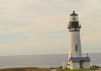 White beautiful lighthouse on the ocean. Blue sky with light white clouds. Beautiful seascape. Ecology, travel, travel destinations advertising, banner, postcard.