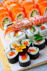Sushi rolls set with salmon and shrimp on light blue background, Flower Shaped Sushi Rolls, Japanese cuisine