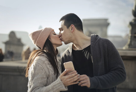 portrait of young couple while taking a selfie while kissing
