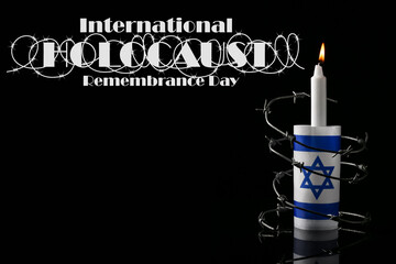 Burning candle, flag of Israel and barbed wire on dark background. International Holocaust...