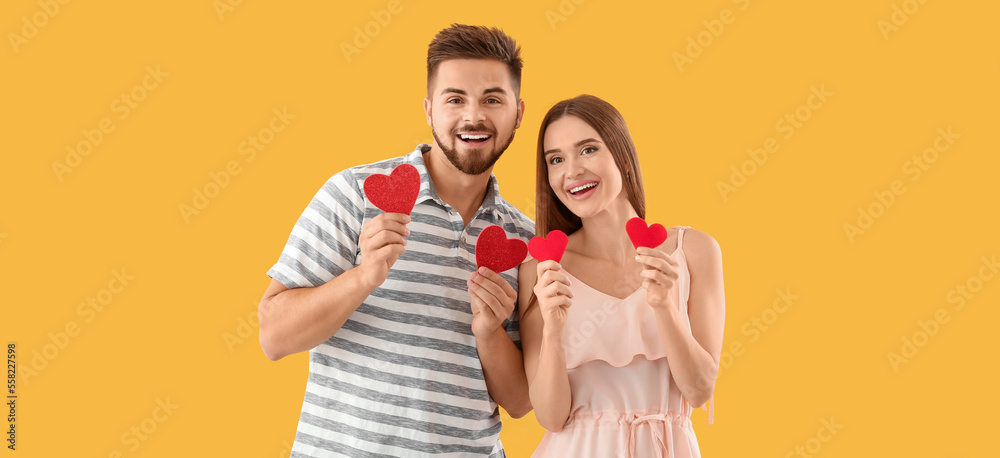 Canvas Prints portrait of happy young couple with paper hearts on yellow background