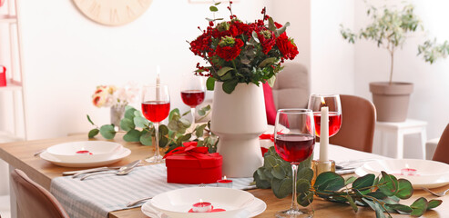 Romantic table setting for Valentine's Day dinner with beautiful flowers in dining room