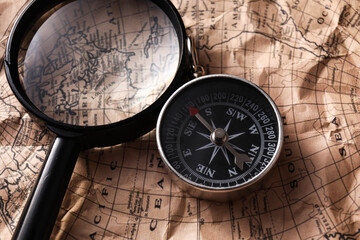 Fototapeta na wymiar Compass and magnifier on world map