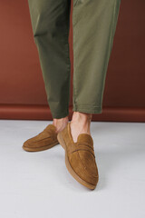 Male feet in brown suede casual shoes. Men's fashionable shoes