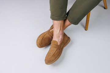 Male feet in brown suede casual shoes. Men's fashionable shoes