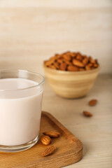 Glass of healthy almond milk on wooden table, closeup