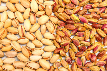 Peeled and unpeeled pistachio nuts as background