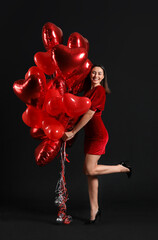 Beautiful woman with balloons on black background. Valentine's Day celebration