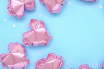 Frame made of pink heart-shaped balloons on blue background. Valentine's Day celebration