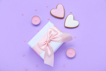 Gift with cookies, candles and hearts on lilac background. Valentine's Day celebration