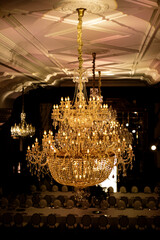 A large baroque chandelier with bright yellow lighting