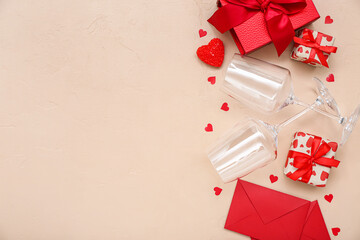 Glasses with envelopes, gifts and hearts on beige background. Valentine's Day celebration