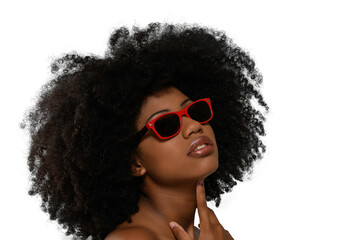 black woman looking up wearing red sunglasses on beige background, close-up portrait