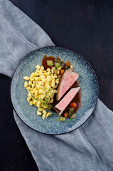 Tafelspitz Braten vom Kalb mit schwäbischen Spätzle and Gemüse serviert mit Dunkelbier Sauce als Draufsicht auf einem Nordic Design Teller 