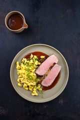 Tafelspitz Braten vom Kalb mit schwäbischen Spätzle and Gemüse serviert mit Dunkelbier Sauce als Draufsicht auf einem Nordic Design Teller 