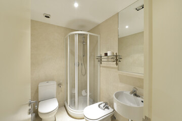 Bathroom with shower cabin with transparent partitions, light marble tiling, frameless mirror and...