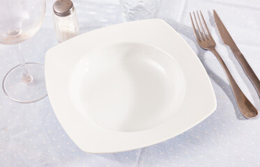 Table setting before the festive banquet - plate, knife and fork