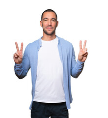 Naklejka premium Happy young man making a victory gesture with his fingers