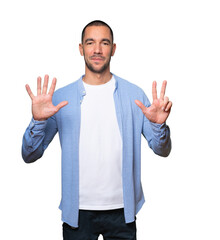 Fototapeta premium Happy young man doing a number eight gesture with his hands