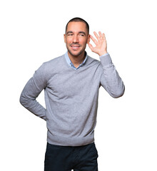 Happy young man smiling and making a gesture of trying to hear something