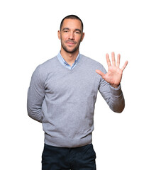 Young man making a number five gesture