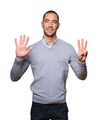 Happy young man doing a number eight gesture with his hands