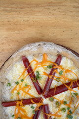 Pizza with mozzarella cheese, cheddar sauce, green onion and smoked sausages. 