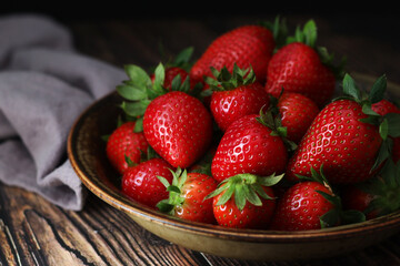 A bowl with ripe bright strawberry in rustic style