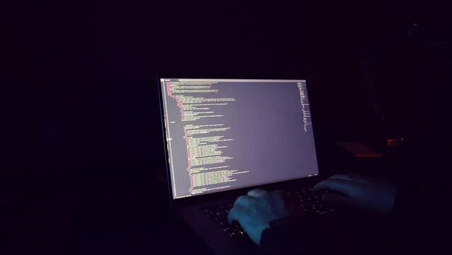 hacker: hacker who writes code. man working on laptop in night light