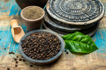 Indian spices collection, dried black peppercorns and another spices in clay bowls