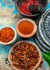 Colorful ground spicy chili peppers , pimento and curcuma is clay pots close up
