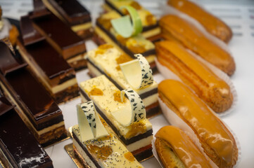 Assortment of french fresh baked sweet pastry with fresh fruits and berries in confectionery shop