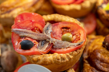 French mini quiche pie with tomatoes, olives and anchovies in bakery