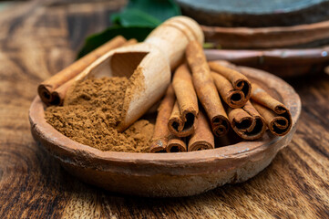 Indian spices collection, dried aromatic cinnamon barks and another spices in clay bowls