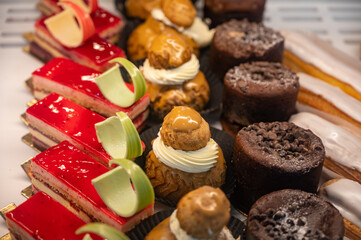 Assortment of french fresh baked sweet pastry with fresh fruits and berries in confectionery shop