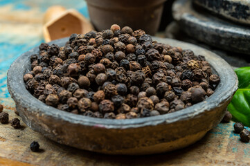 Indian spices collection, dried black peppercorns and another spices in clay bowls