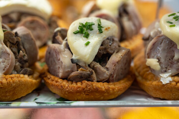 French mini quiche pie with goat cheese and traditional French sausage Andouillette from Troyes in...