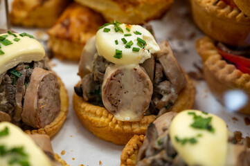French mini quiche pie with goat cheese and traditional French sausage Andouillette from Troyes in bakery