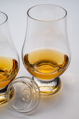 Tulip-shaped tasting glasses with dram of Scotch single malt or blended whisky on white background