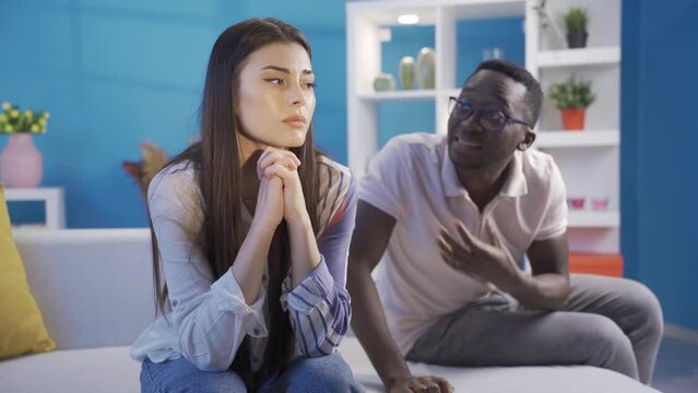 Interracial married couple fighting at home in the evening. Scandal and crisis in the family. Domestic violence, harassment.