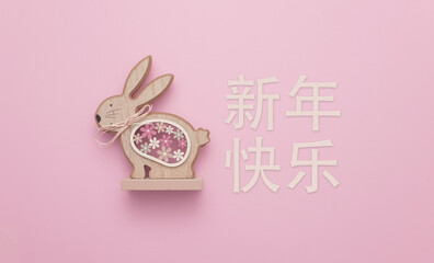 Happy Chinese New Year (新年快乐), the year of the Rabbit. A cute wooden sculpture of a rabbit...